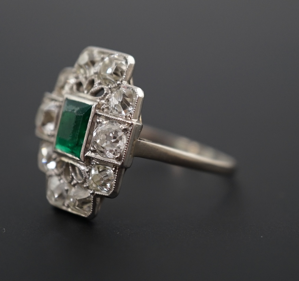 An early to mid 20th century white gold?, emerald and diamond cluster set stepped oval dress ring